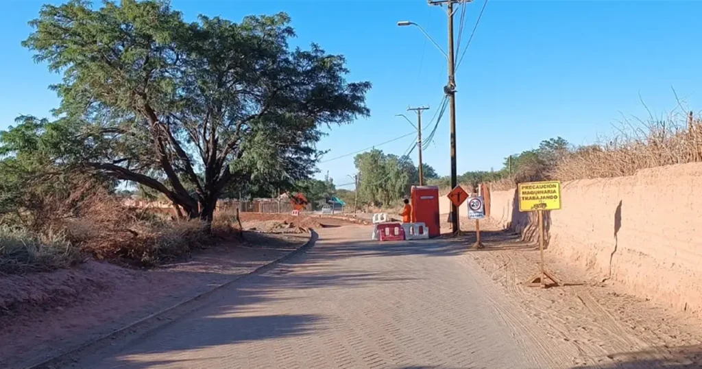 Camino rural con señalización de trabajos y barreras de tránsito en sector de San Pedro de Atacama