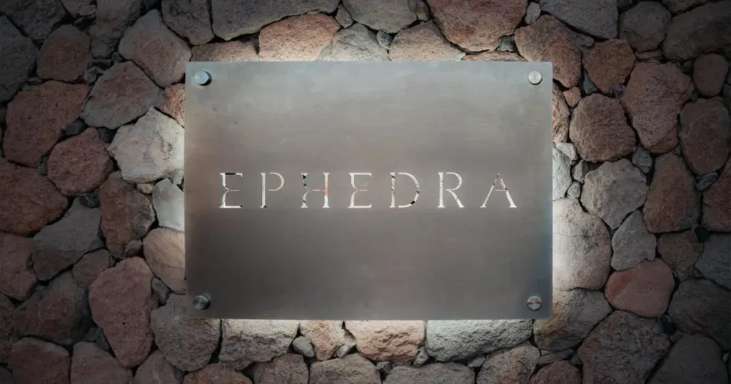 Placa metálica con el nombre Ephedra instalada sobre muro de piedra en San Pedro de Atacama