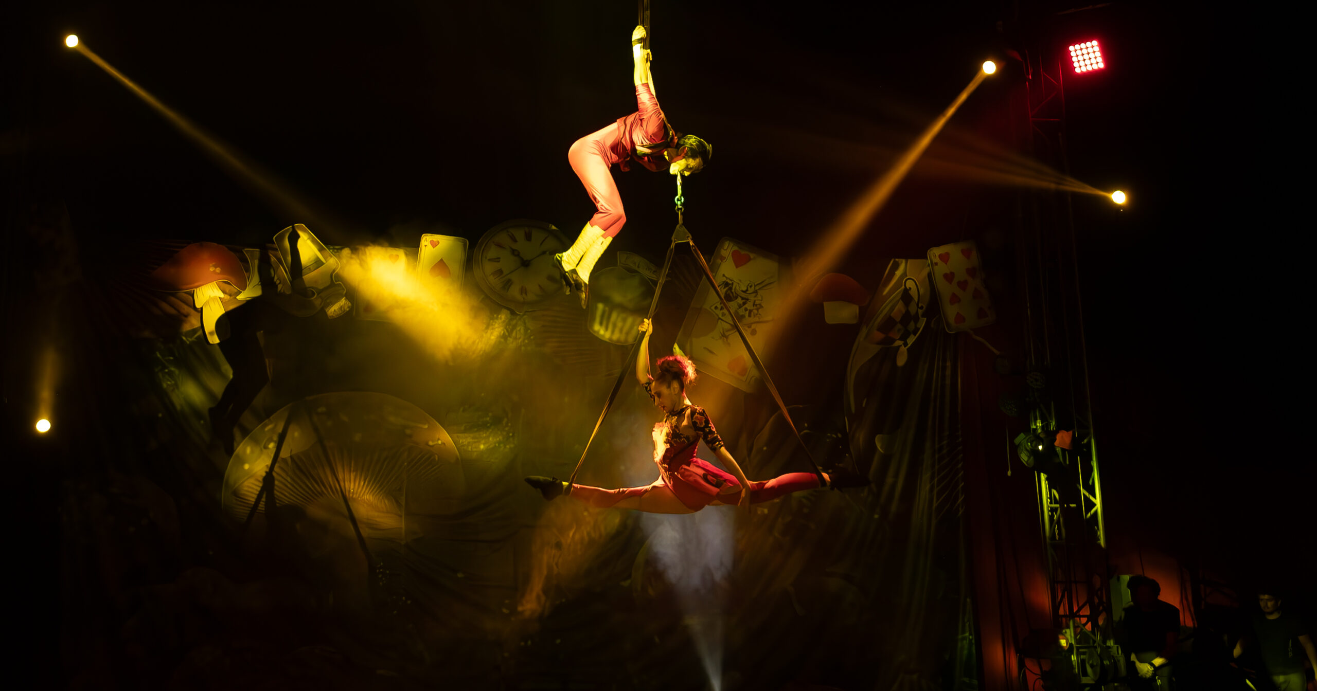 Dos artistas realizan acrobacias aéreas durante el circo en San Pedro de Atacama inspirado en Alicia en el País de las Maravillas.